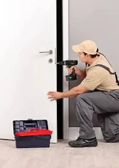 Cerrajero instalando una cerradura en una puerta residencial.